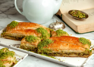 side view of turkish sweets triangular shapedbaklava with pistachio on a platter